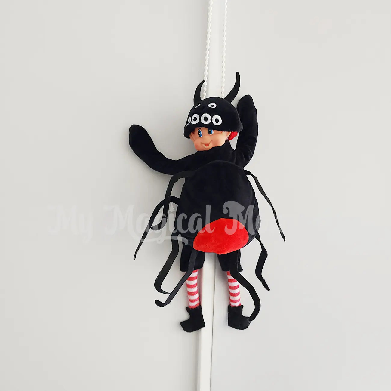 elves behavin badly in an elf spider outfit hanging from the blinds