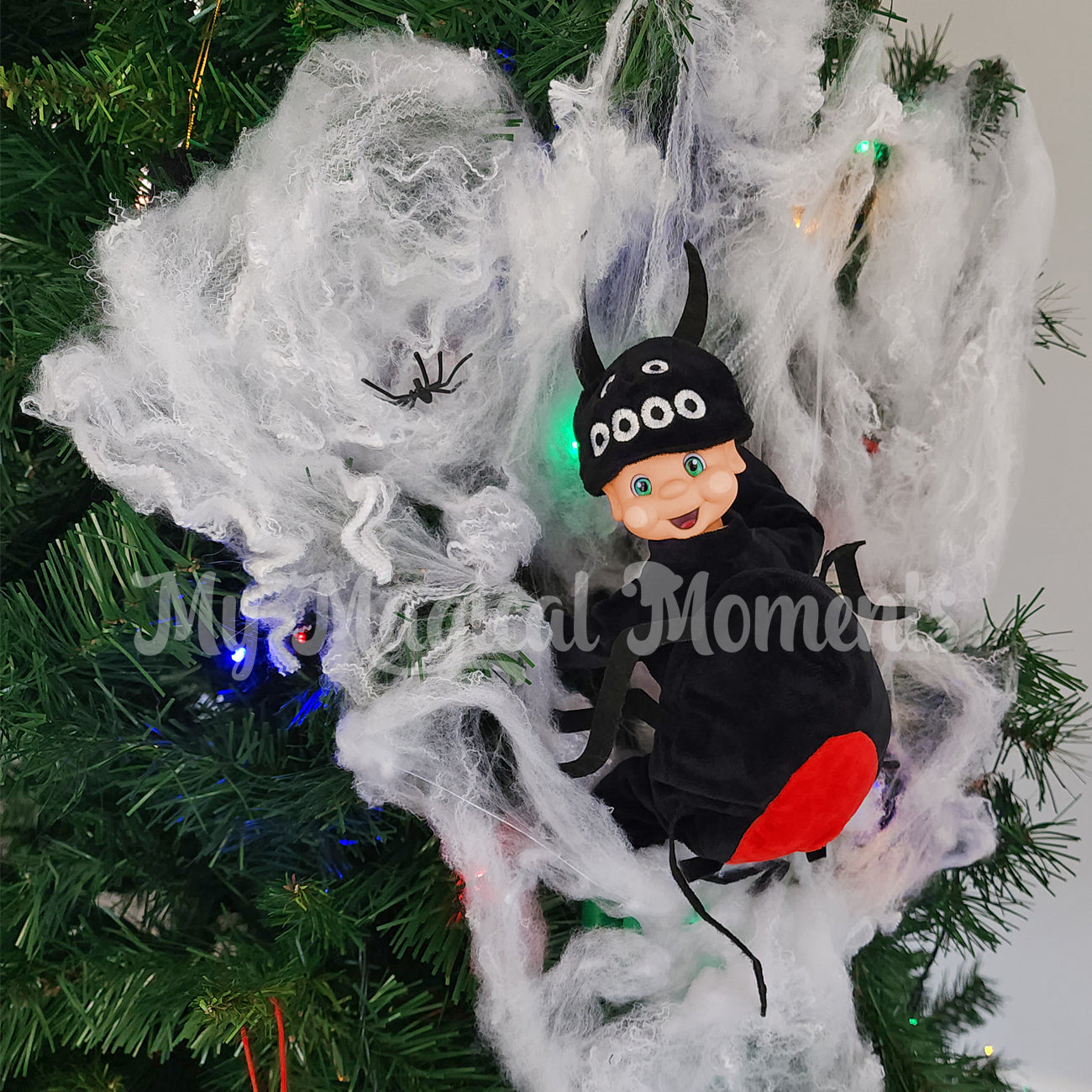 my elf friends dressed as a spider in a spider web in the tree with miniature fly props