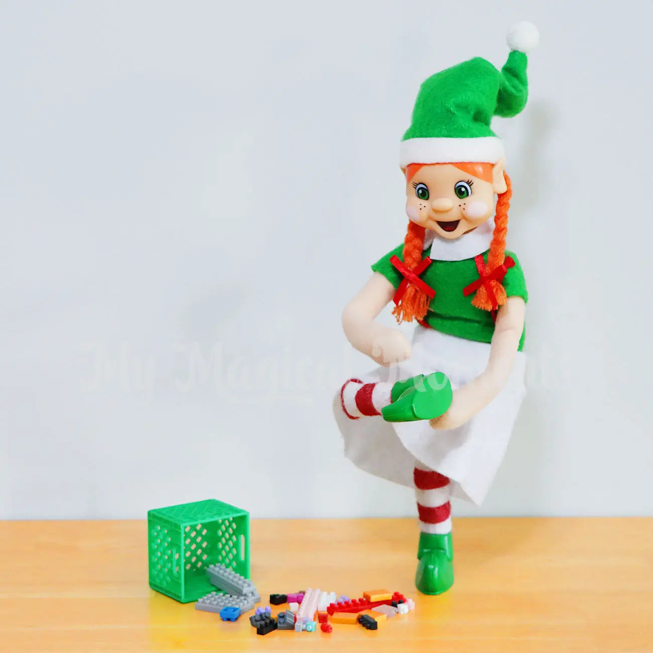 Elf stepping on lego on the floor with a crate