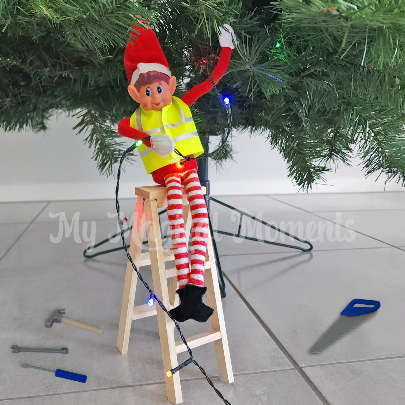 Elves behavin badly standing on a ladder decorating a Christmas tree