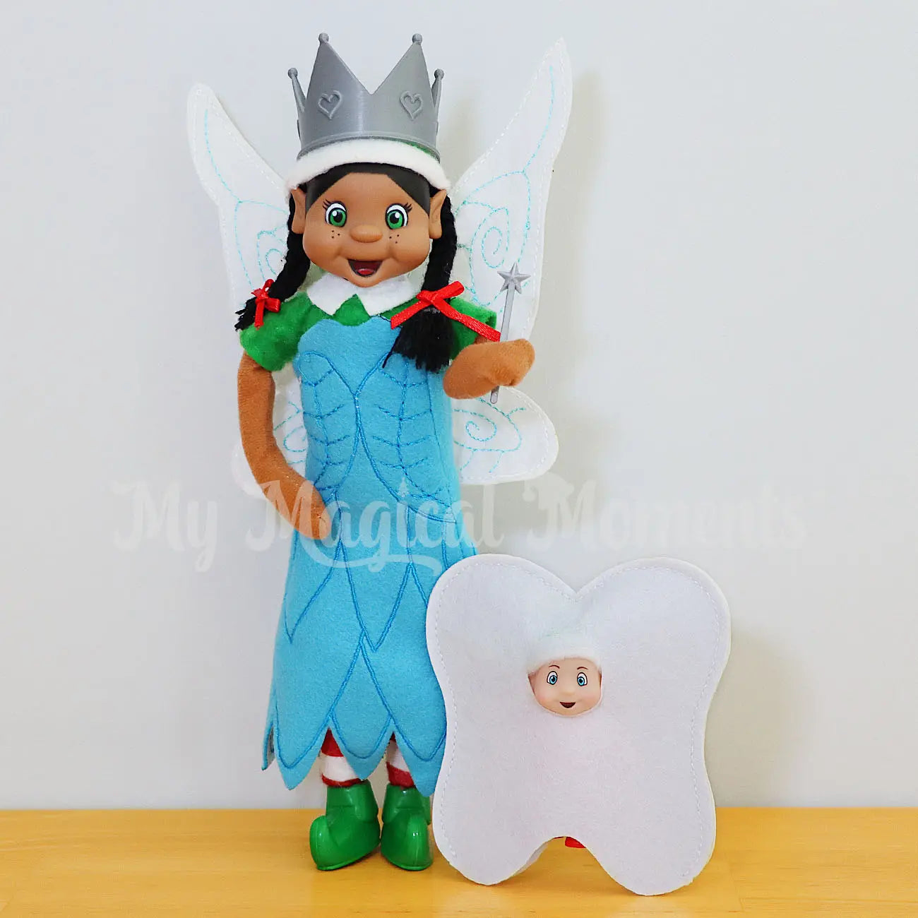 Tooth fairy elf with elf baby wearing a tooth costume