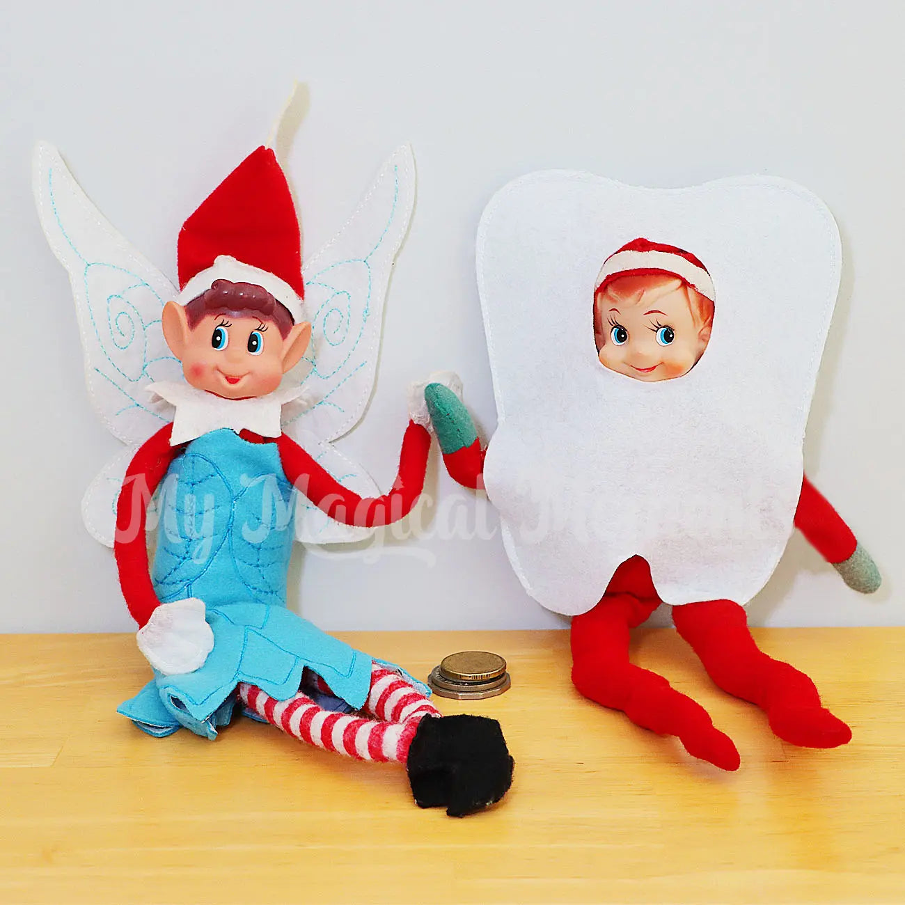 Elf wearing a fairy costume with an elf wearing a tooth costume being a tooth fairy