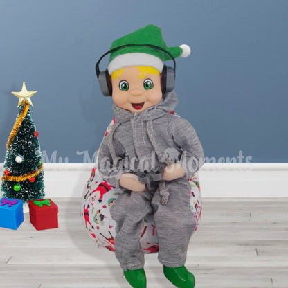 Elf wearing trackies and headphones. Sitting on a miniature bean bag playing a game