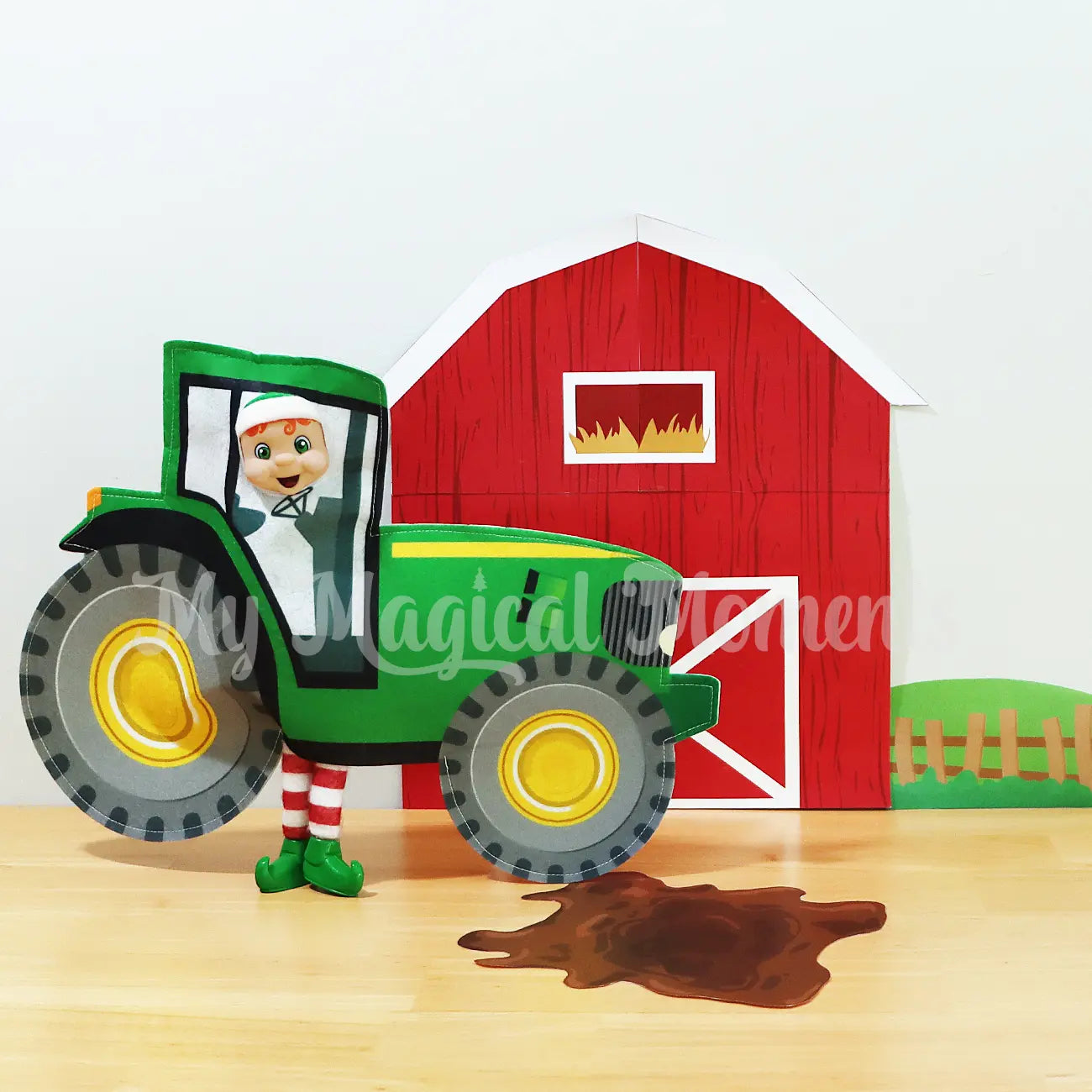 Elf wearing a tractor in front of a free elf barn printable with mud