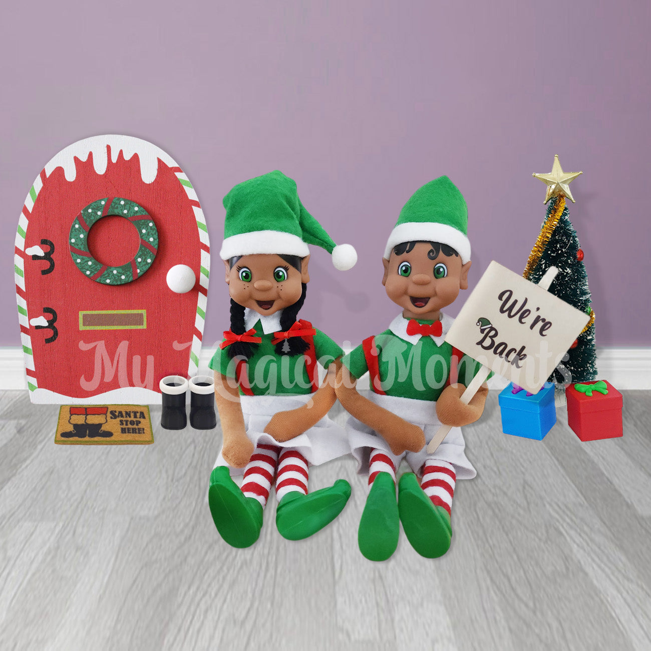 elves holding a welcome back sign with an elf door