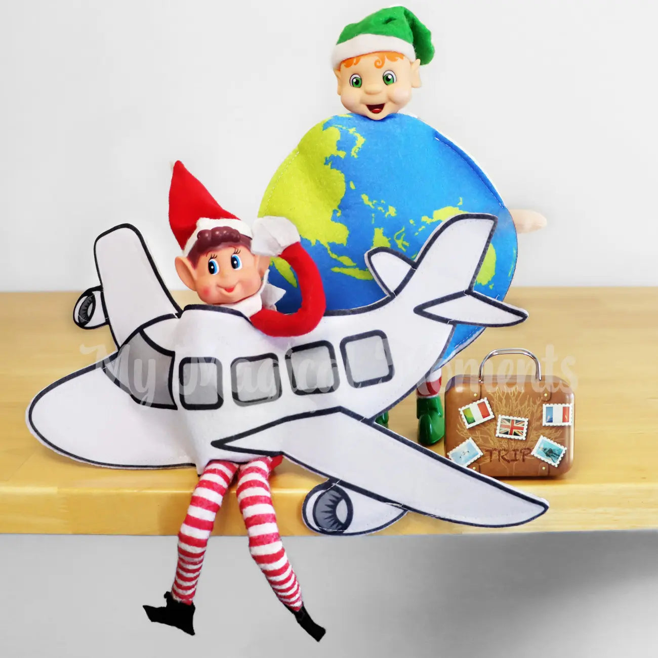 Elf wearing a globe costume, another wearing a plane costume and a suitcase