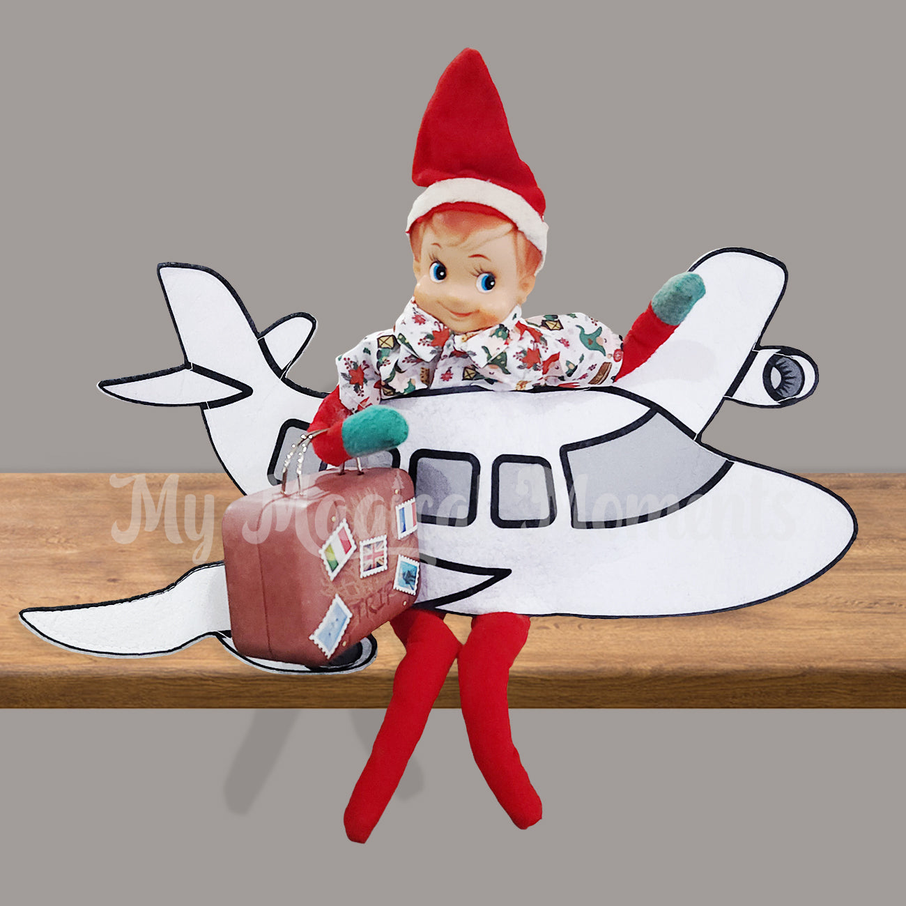 Vintage elf siting on a shelf holding a miniature suitcase in a plane costume