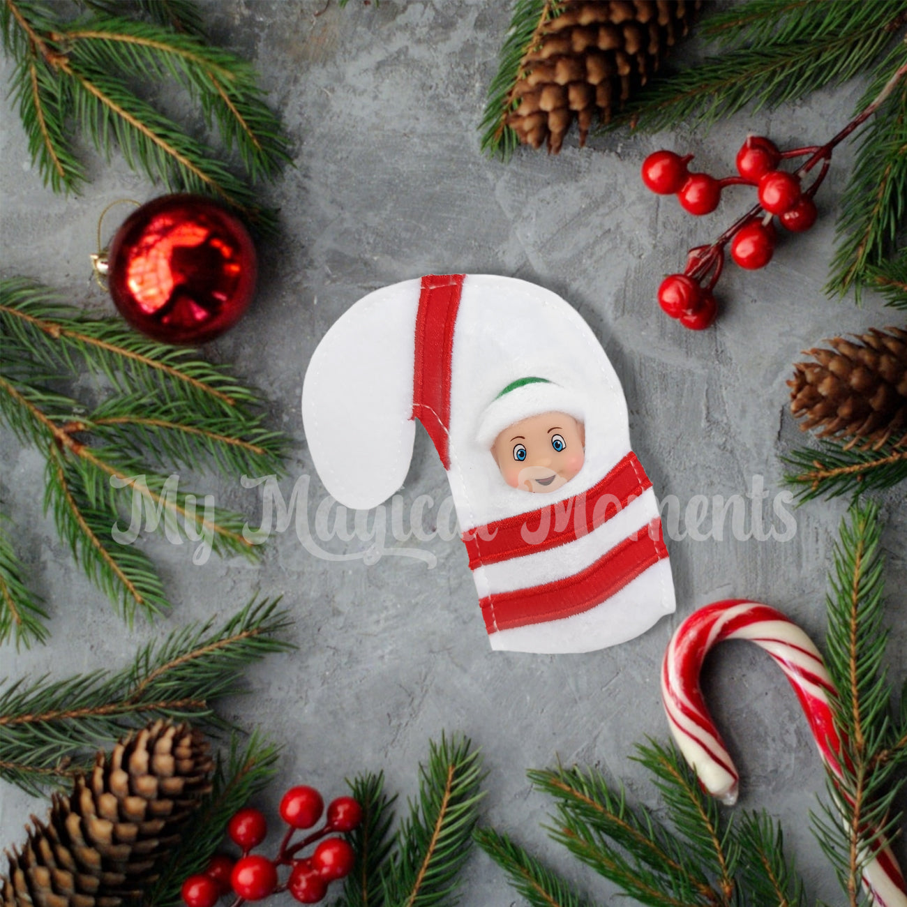 Elf baby wearing a candy cane costume amongst Christmas decor