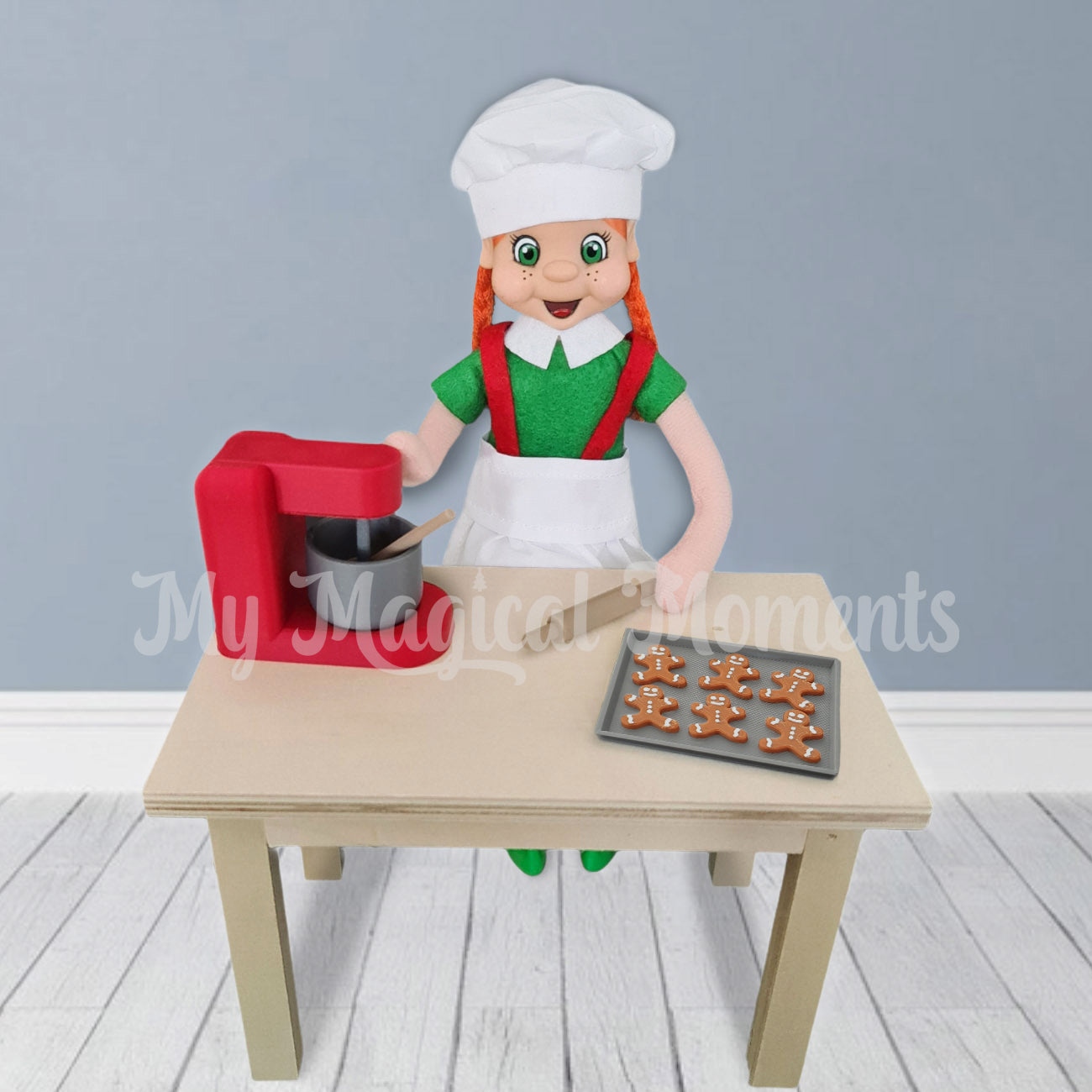 Elf making mini gingerbread cookies with red mixer