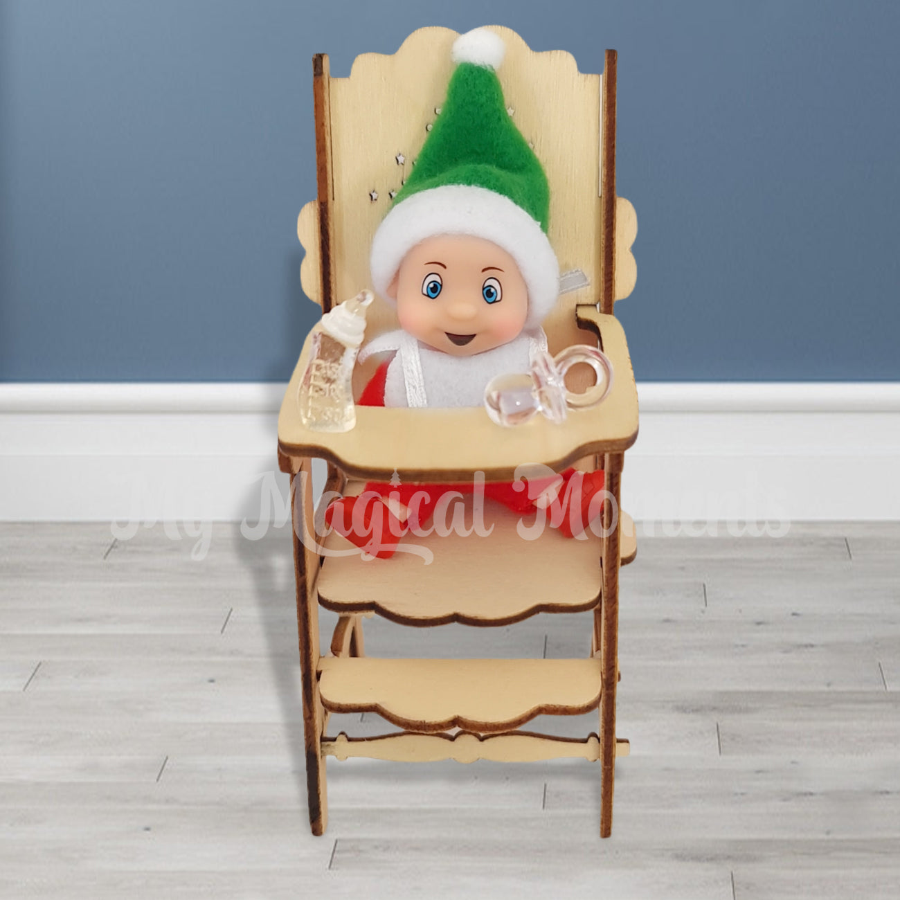 elf baby sitting in high chair with bottle and dummy