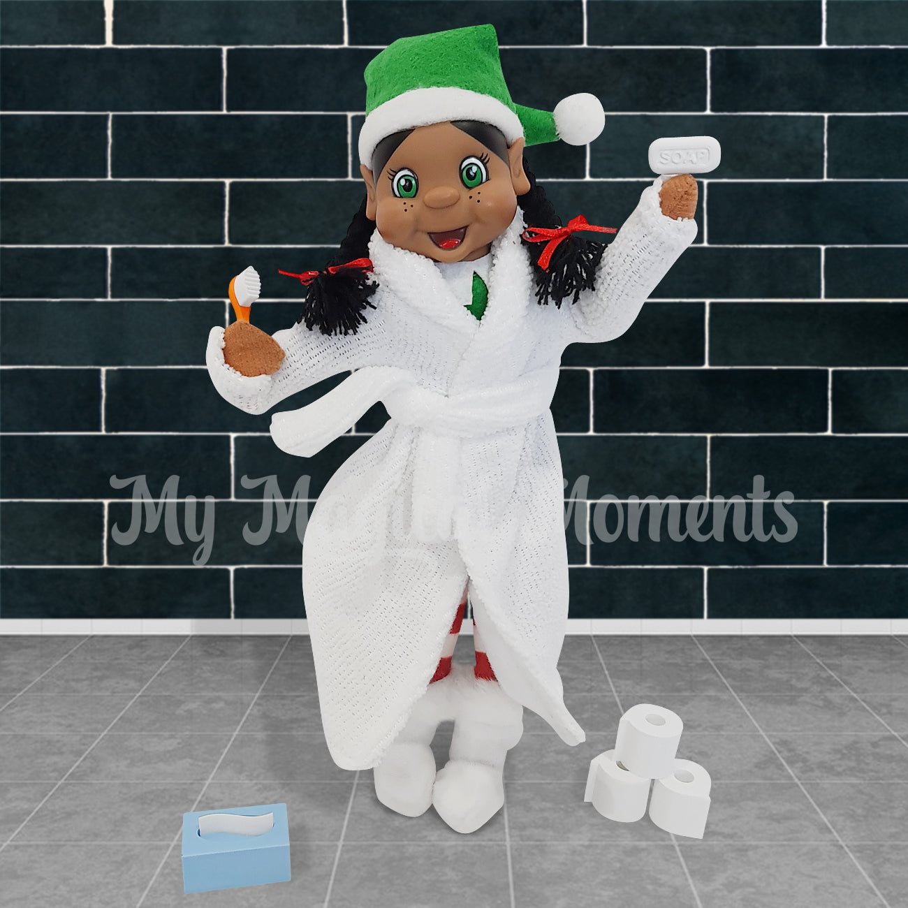 Black hair elf dressed in a bathrobe holding a mini toothbrush and soap. She's standing in the bathroom with toilet paper and tissues at her feet