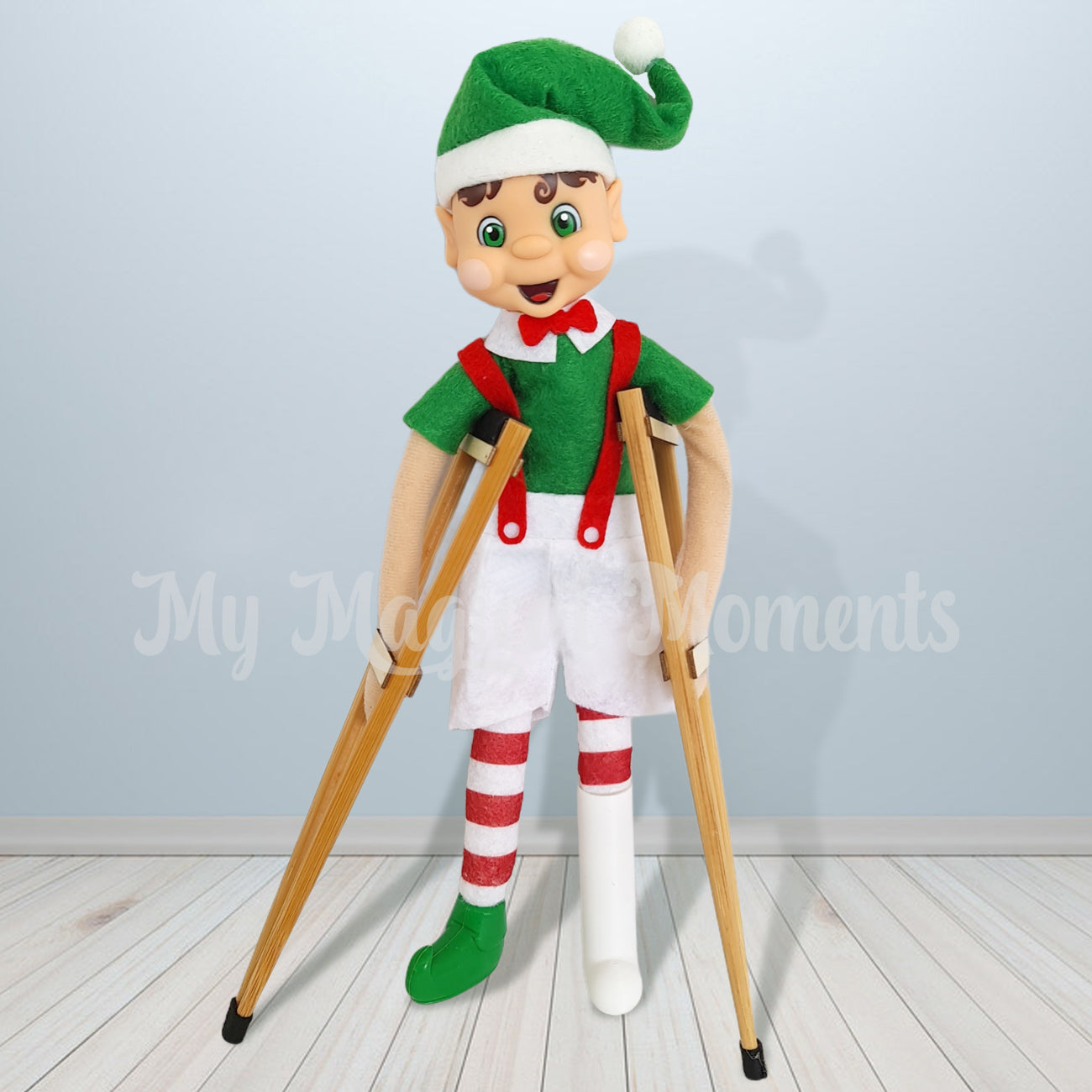 My elf friend with brown hair holding his crutches with a broken foot. In a miniature leg cast
