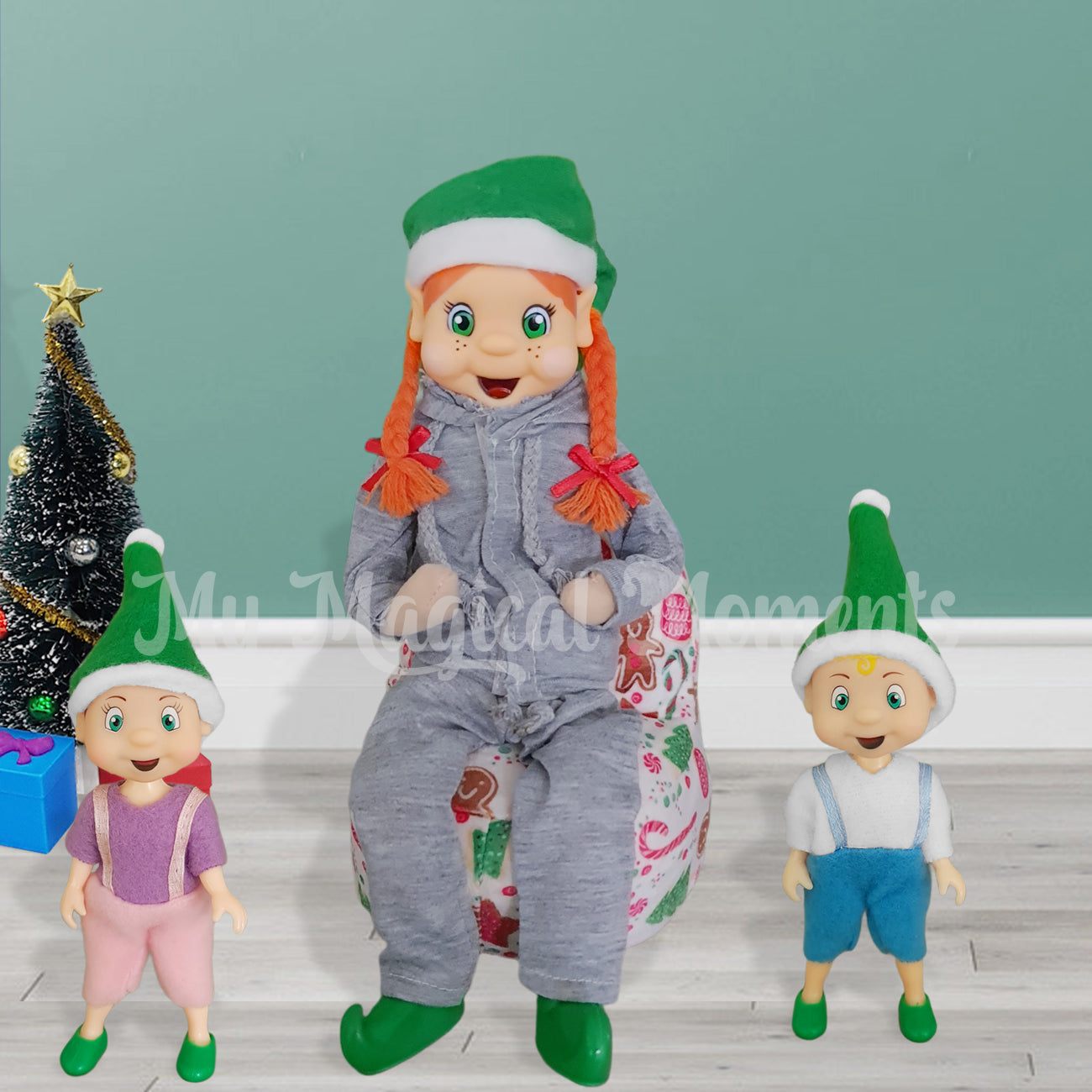 Tracksuit wearing elf sitting on a bean bag with elf toddlers next to her