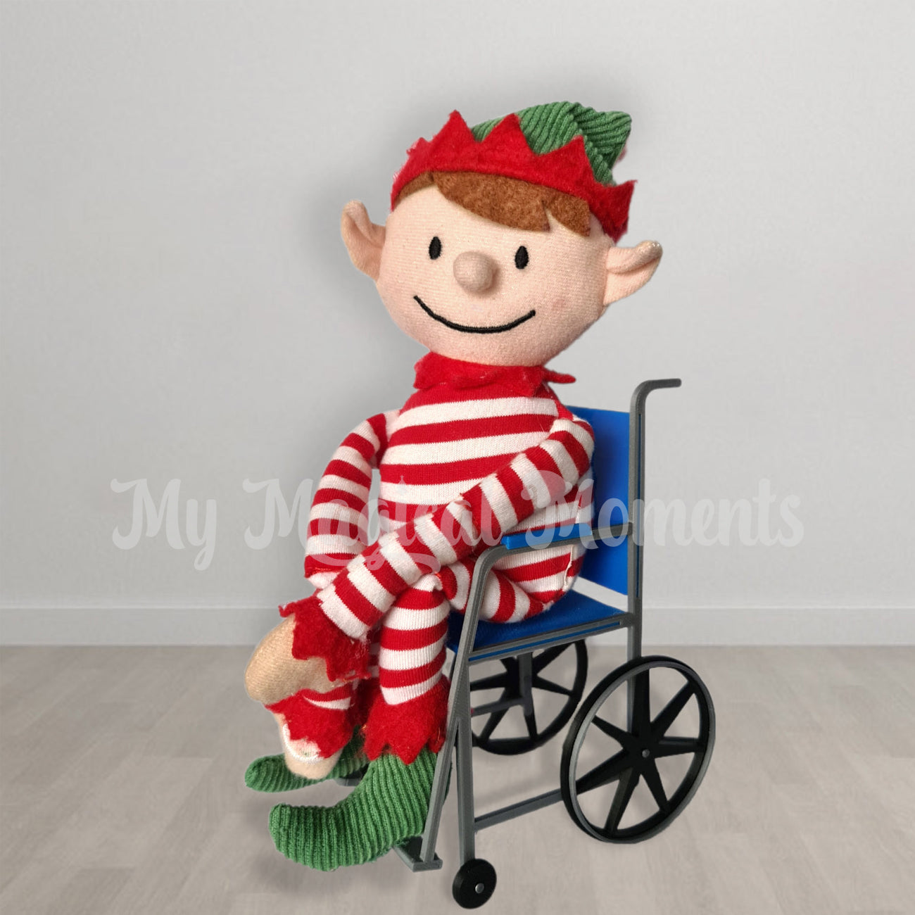 An elf for christmas in a blue miniature wheelchair
