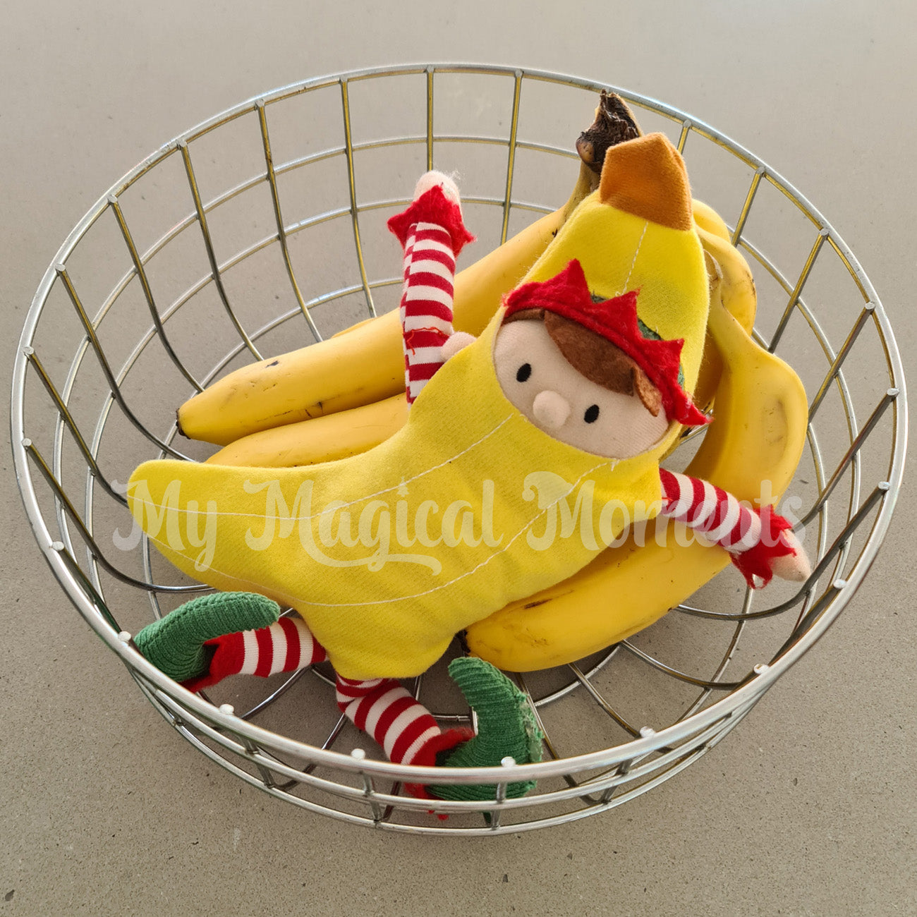 an elf for christmas dressed as a banana costume hiding in bananas