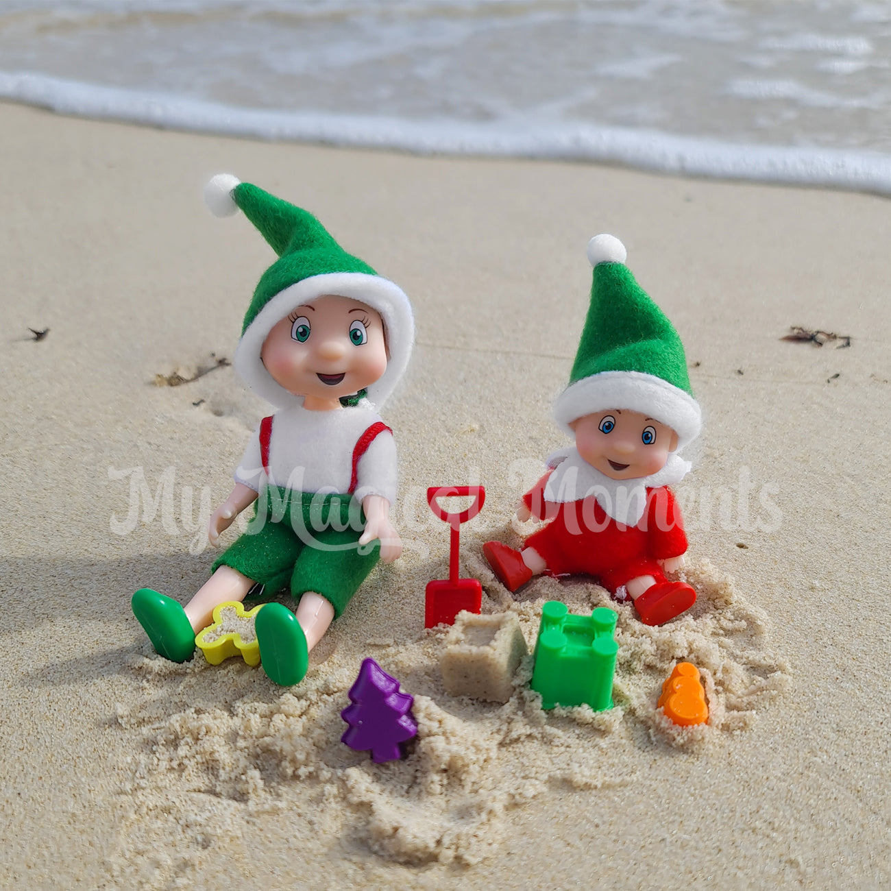 Elf toddler and Elf baby playing with miniature beach sand toys on a beach